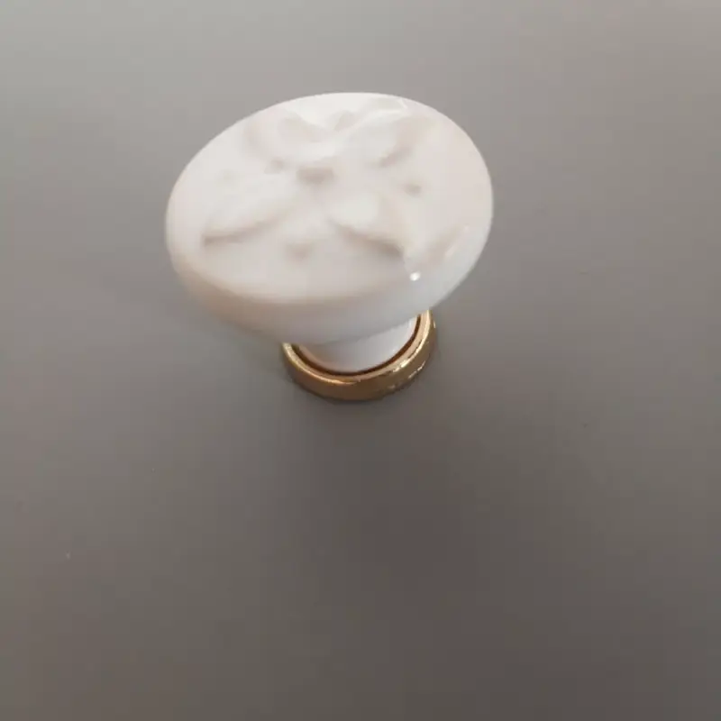 Újdonság Fém-porcelán bútorgomb, fehér színű, arany talprésszel, virág formájú