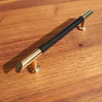 Metall-Kunststoff-Möbelgriff, Farbe gold-schwarz, BA 96 mm Végkiárusítás